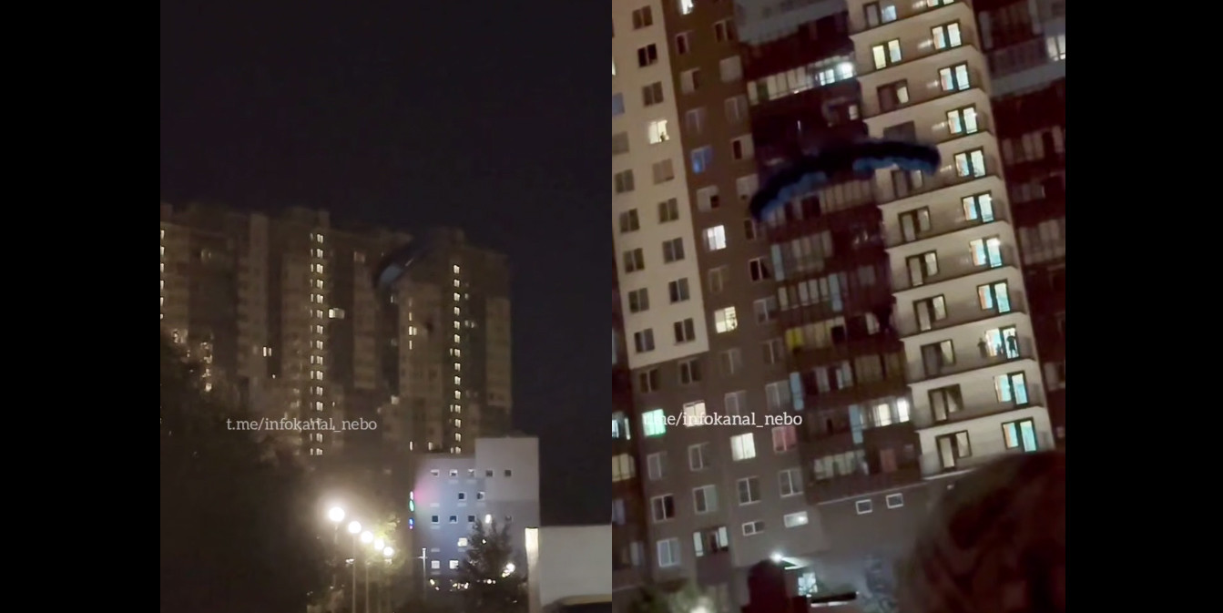 мужчина с парашютом летит после прыжка с жилой многоэтажки